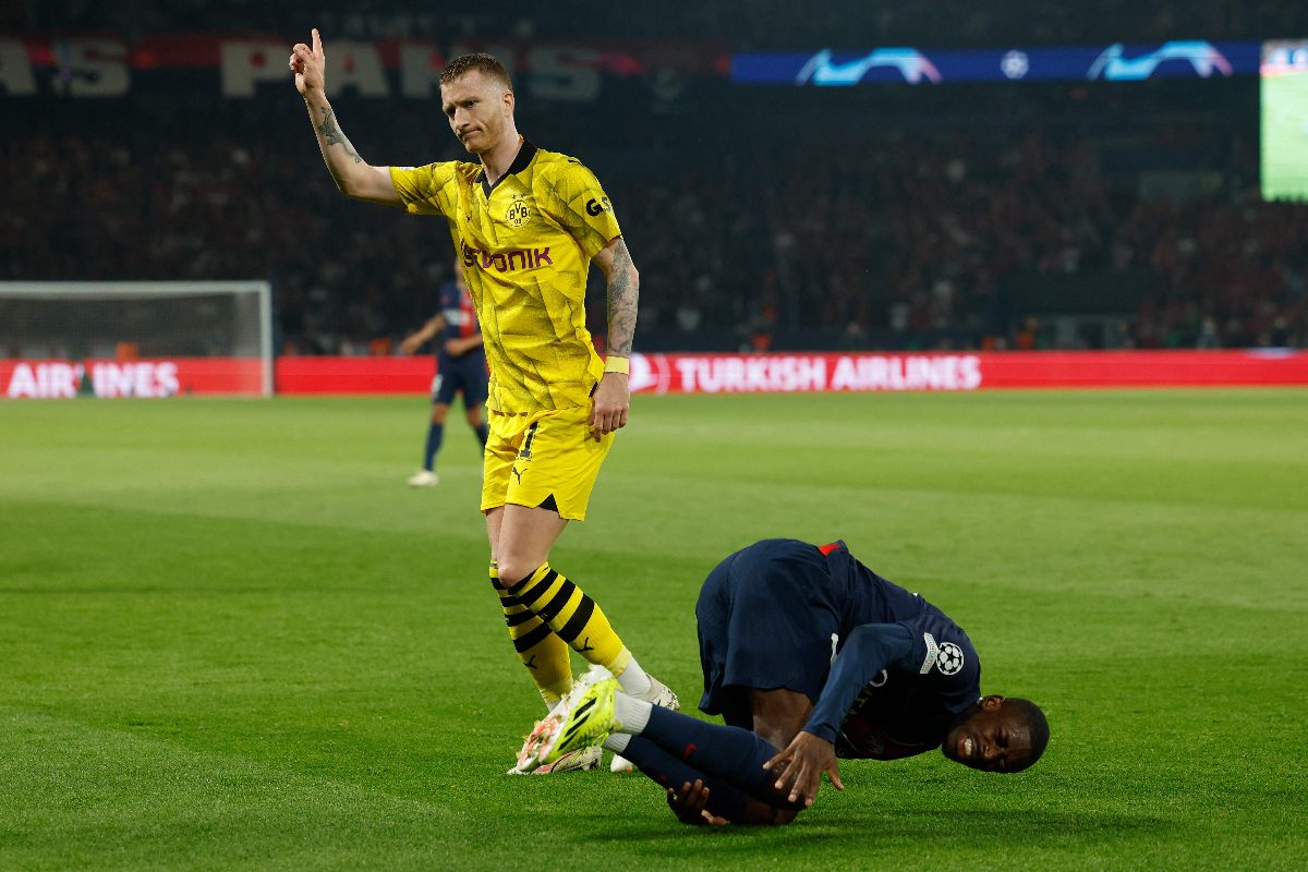 Penyerang Dortmund asal Jerman #11 Marco Reus (kiri) melakukan pelanggaran terhadap penyerang Prancis Paris Saint-Germain #10 Ousmane Dembel