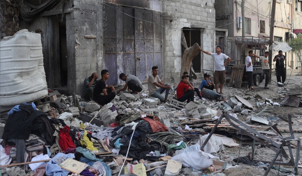 Warga Palestina duduk di dekat reruntuhan rumah mereka yang hancur akibat pengebomam Israel di lingkungan Tal al-Sultan, Rafah, Jalur Gaza.