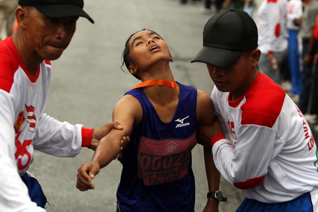 Juara pertama lomba lari 10K kategori perempuan Tyaningsih kelelahan ketika finish di Monas,Jakarta,Minggu (26/9).