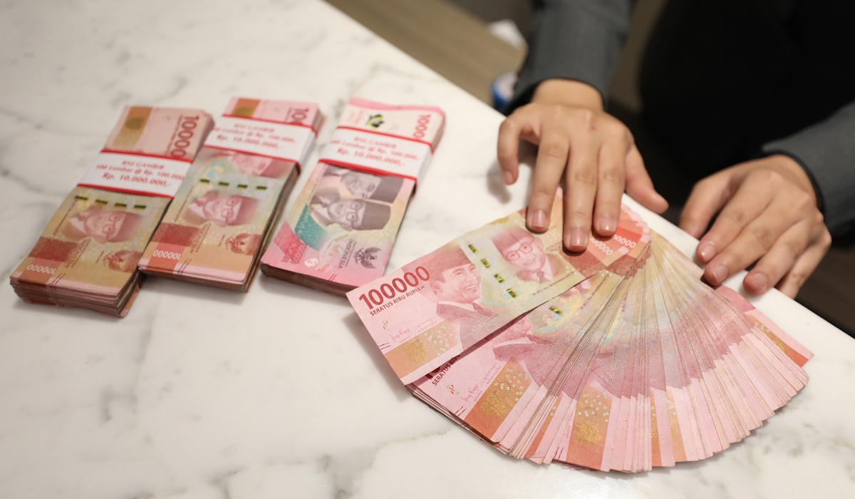 Petugas menunjukkan mata uang rupiah di salah satu kantor cabang PT Bank Negara Indonesia (BNI) Tbk. di Jakarta 