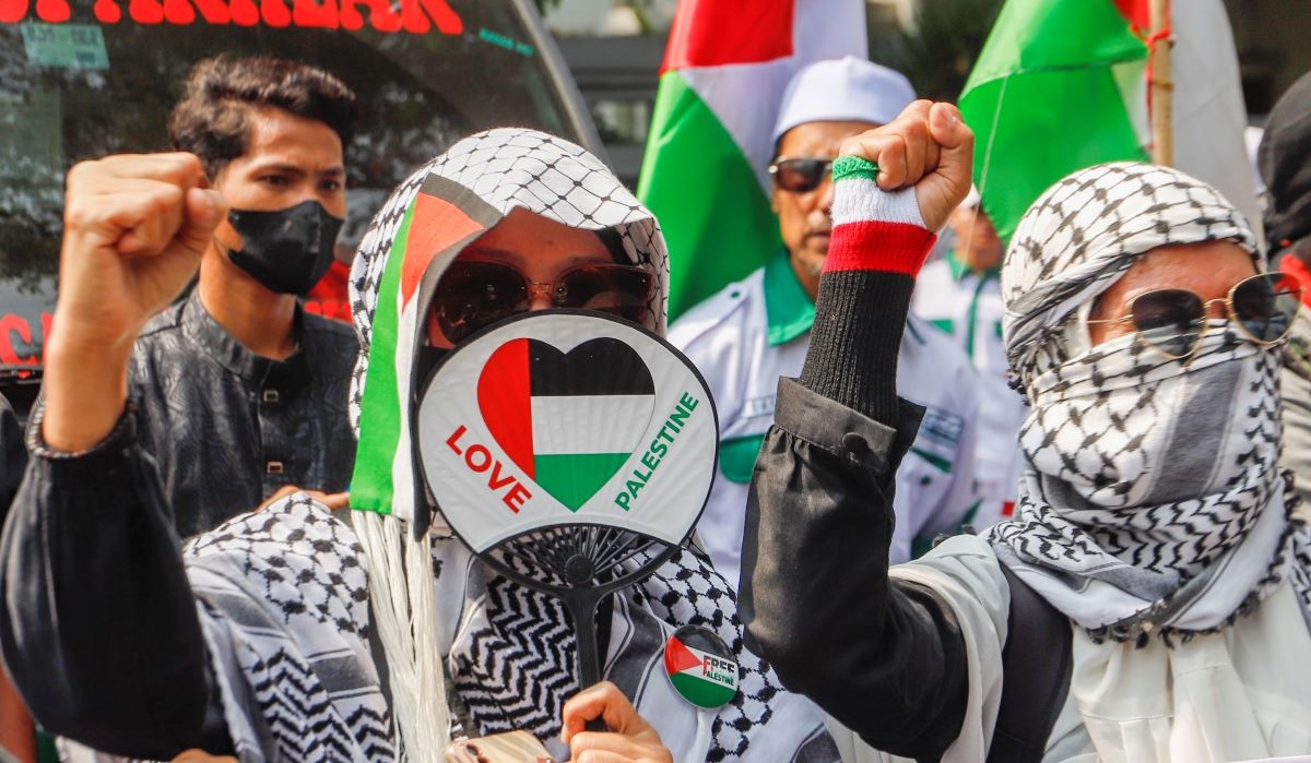 Pengunjuk rasa memegang poster Stop Genosida di Gaza saat Aksi Bela Palestina di Kantor Kedutaan Besar Mesir, Jakarta, Minggu (19/5/2024).