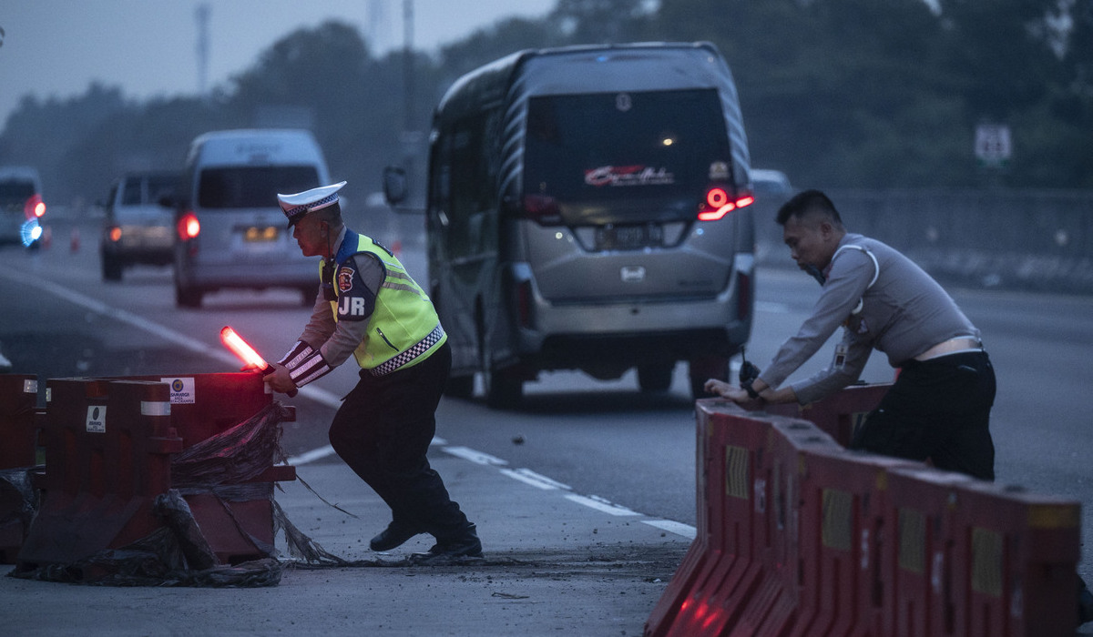 Polisi Lalu Lintas mendorong pembatas jalan menjelang pemberlakuakn contraflow di kawasan Gerbang Tol Cikampek Utama, Karawang.