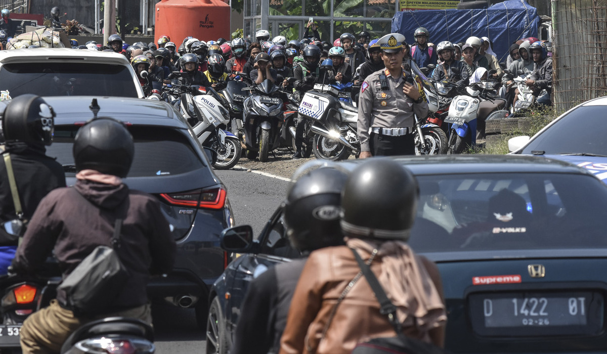 Polisi mengatur kendaraan pemudik saat pemberlakuan sistem satu arah (one way) di Jalur Selatan, Malangbong, Kabupaten Garut.