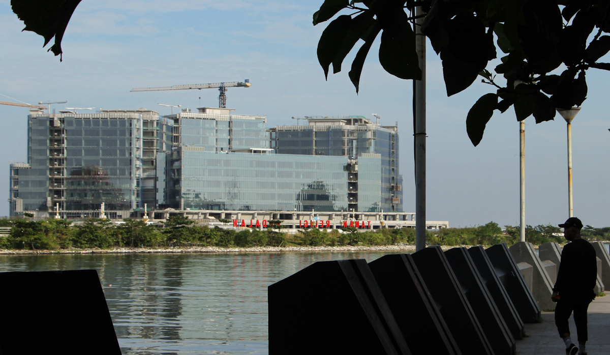 Seorang pejalan kaki melintas di samping proyek pembangunan Rumah Sakit UPT Vertikal Makassar 