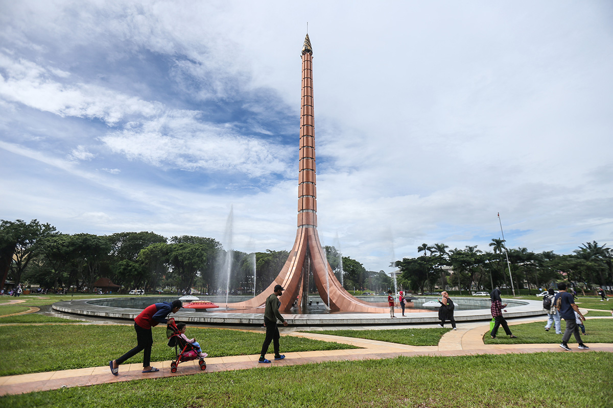 Sejumlah pengunjung berjalan di kawasan Tugu Api, Taman Mini Indonesia Indah (TMII), Jakarta Minggu (20/11/2022).