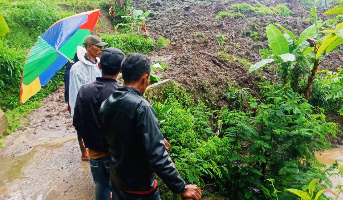 Warga melihat kondisi longsor yang menutup akses dua desa di Kecamatan Gununghalu, Kabupaten Bandung Barat.