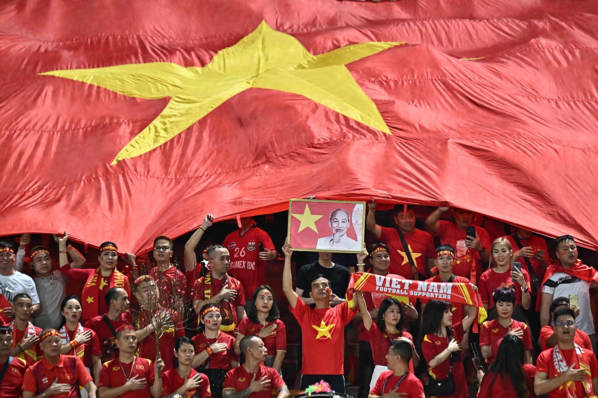 Suporter timnas Vietnam mengibarkan bendera negara mereka di final Piala AFF 2023.
