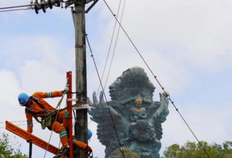 Petugsa melakukan perbaikan jalur listrik di wilayah Bali