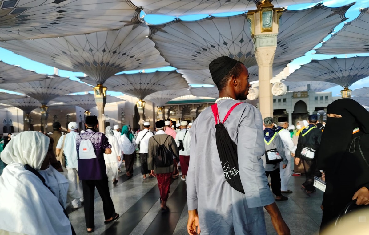 Ilustrasi - Seorang Petugas Haji menunjukkan totalitasnya dengan membantu jemaah haji lansia