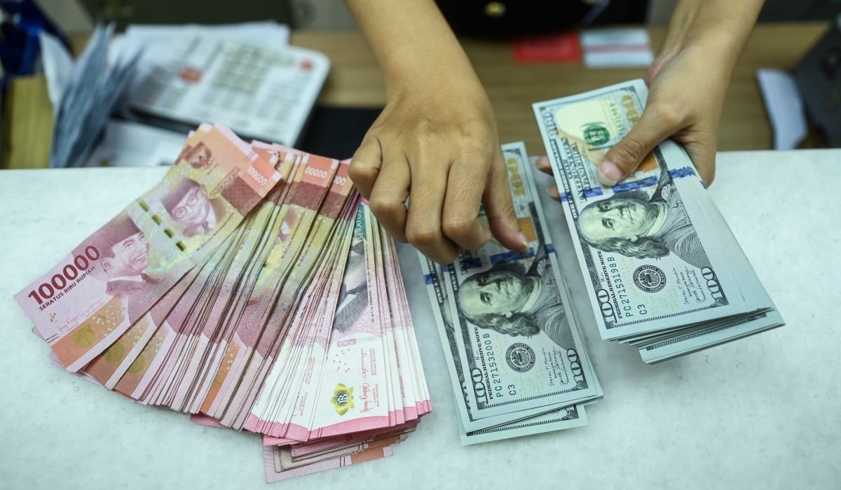 Petugas menghitung uang pecahan rupiah dan dolar AS di gerai penukaran mata uang asing Jakarta, Rabu (22/5/2024). 