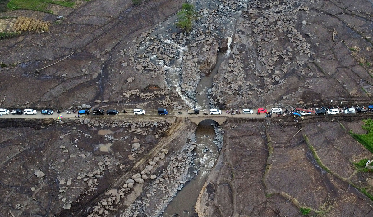 Foto udara kendaraan antre melewati jembatan yang terdampak banjir bandang di Tanah Darat, Sumbar.