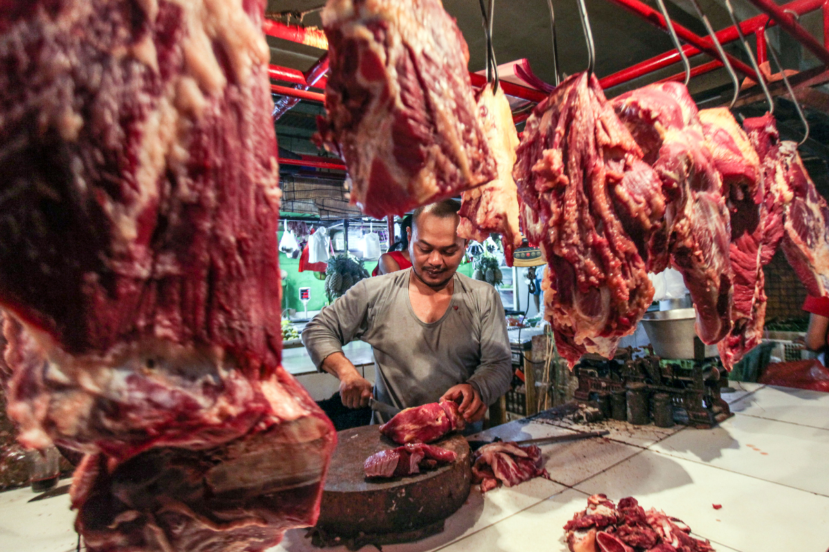 Pedagang memotong daging sapi untuk pembeli di Pasar Cibinong, Kabupaten Bogor, Jawa Barat, Senin (1/4/2024). Sejumlah harga komoditas bahan
