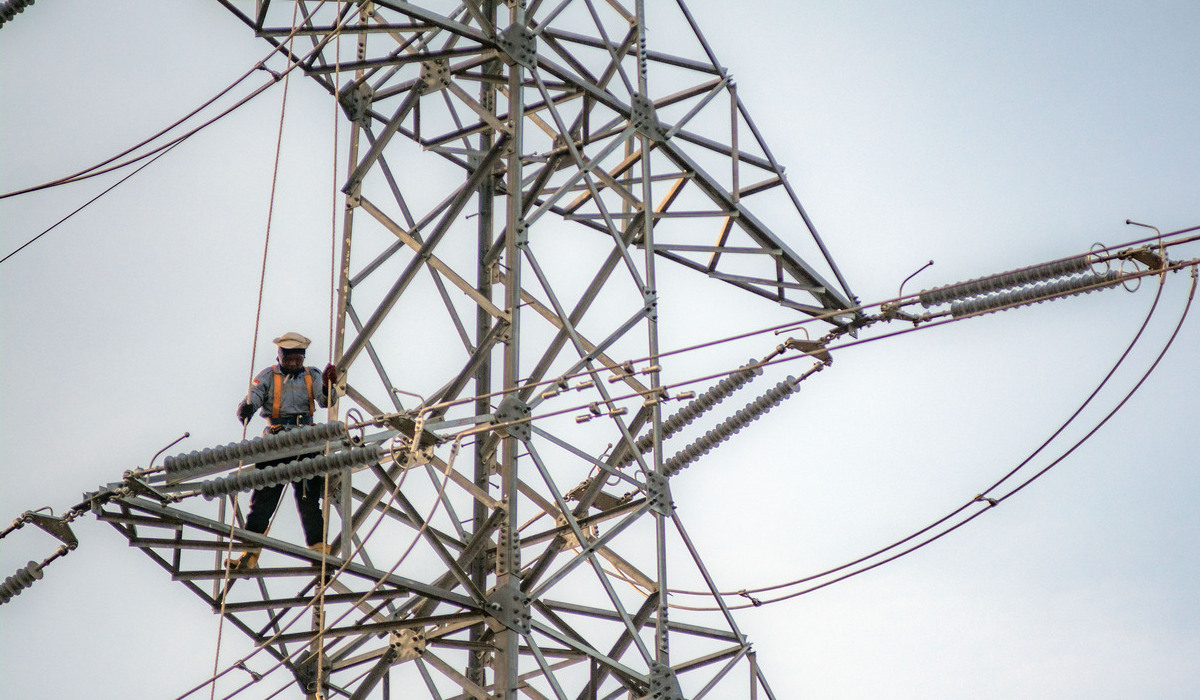 Pekerja melakukan perawatan jaringan kelistrikan di sebuah tower transmisi di Palu.