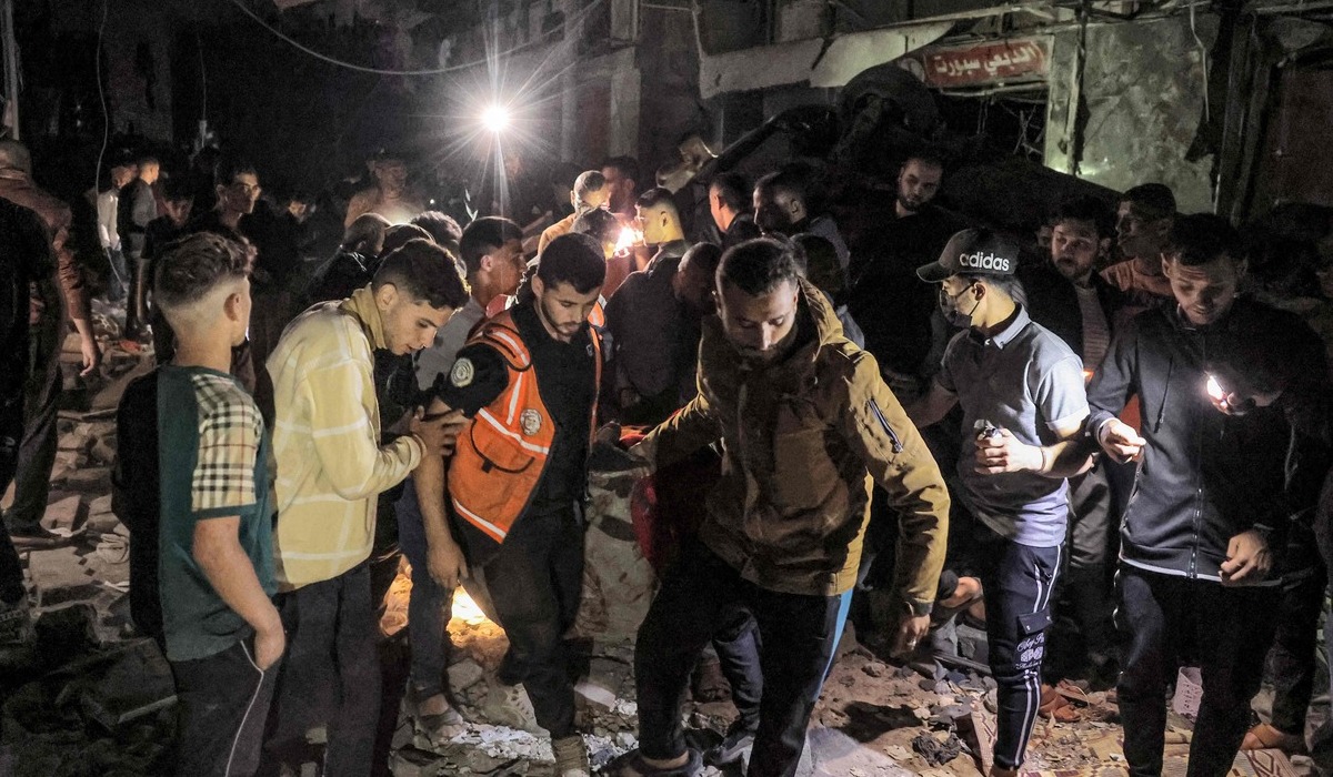 Petugas menggotong tubuh korban tewas akibat serangan Israel di Rafah.