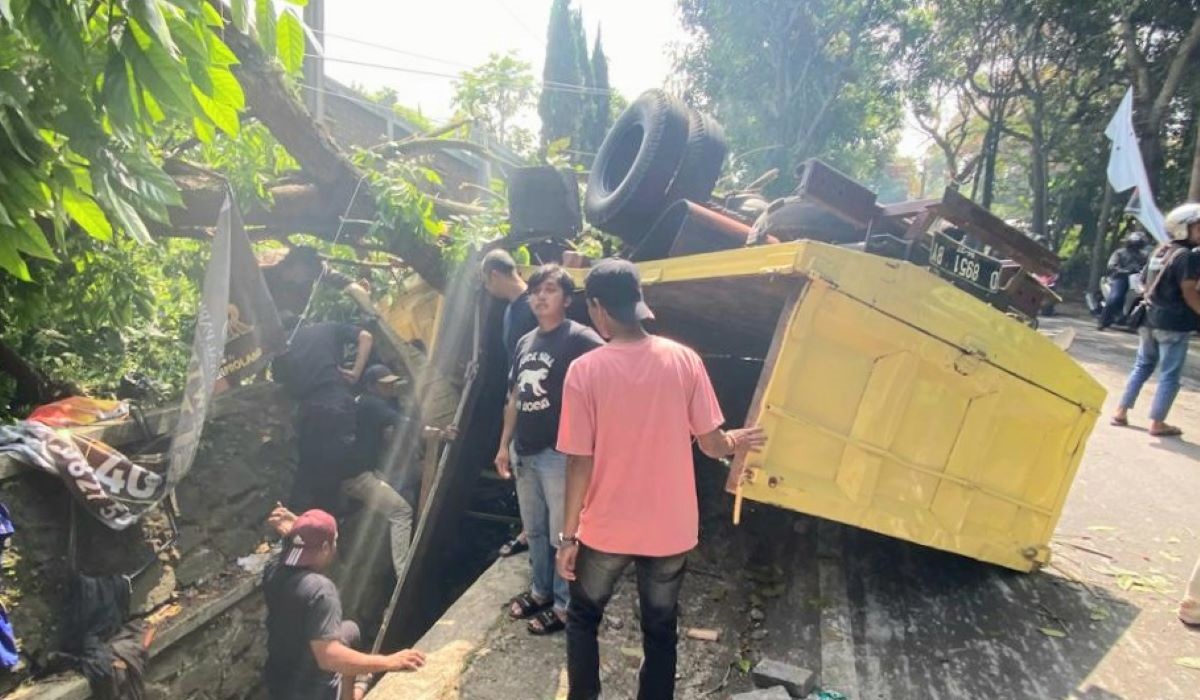 Petugas dan warga mengevakuasi kernet truk yang terjepit saat kecelakaan di turunan Jalan Kolmas, Kota Cimahi, Senin (27/5).