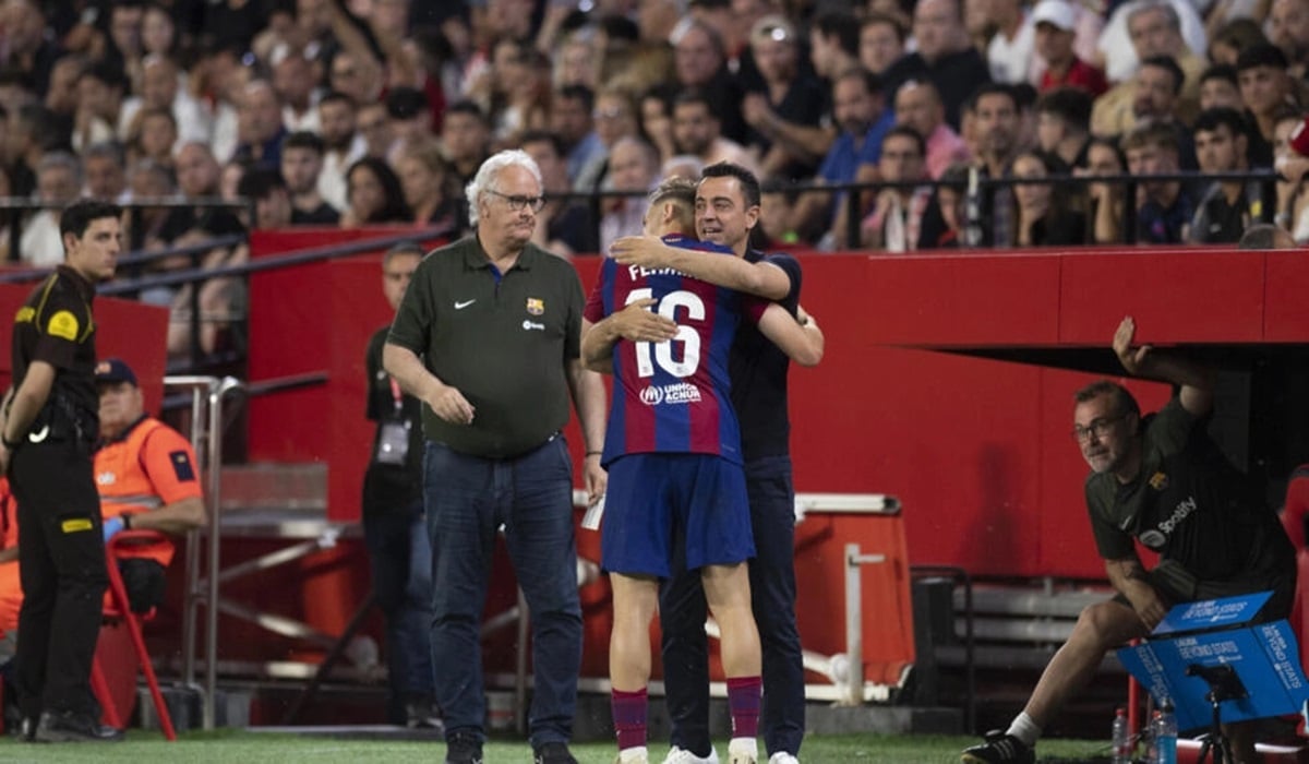 Gelandang Barcelona Fermin Lopez memeluk pelatih Xavi Hernandez usai mencetak gol ke gawang Sevilla di laga La Liga.
