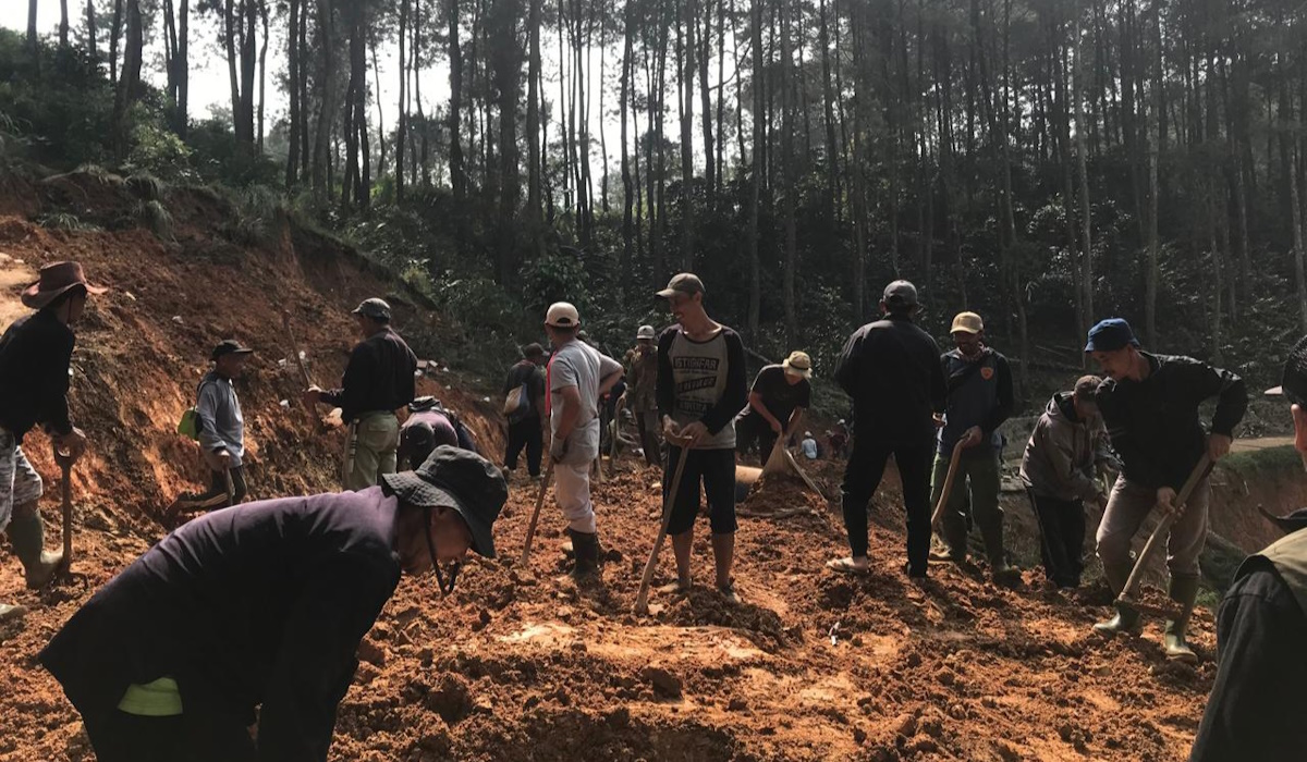 Warga membersihkan material longsor yang menutup akses jalan di Kecamatan Gununghalu, Kabupaten Bandung Barat.
