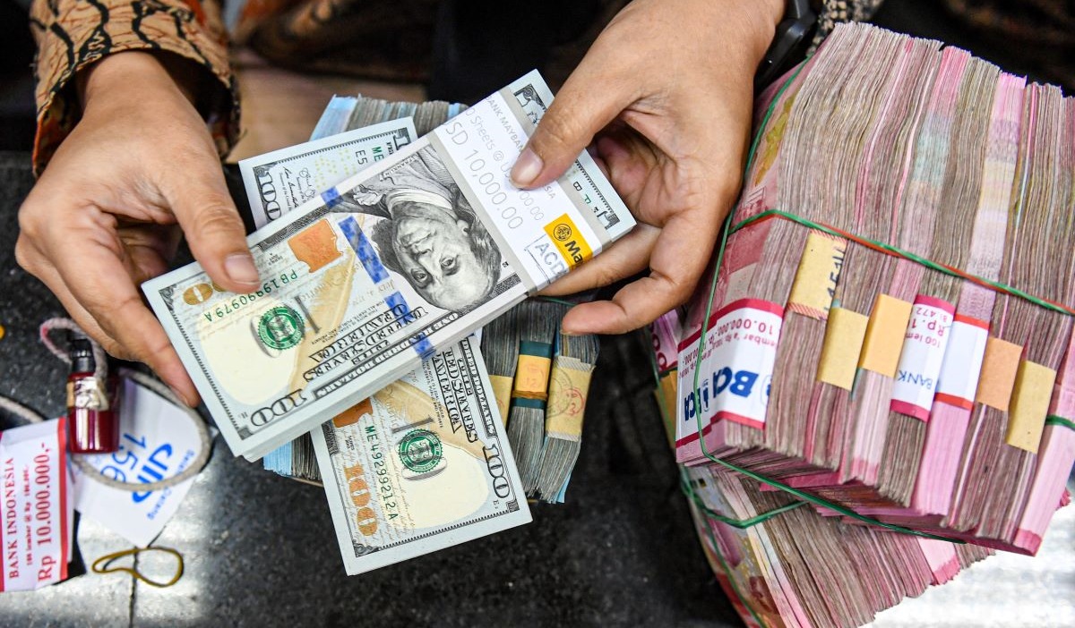 Petugas menyusun uang pecahan dolar AS dan rupiah di gerai penukaran mata uang asing VIP (Valuta Inti Prima) Money Changer, Jakarta.