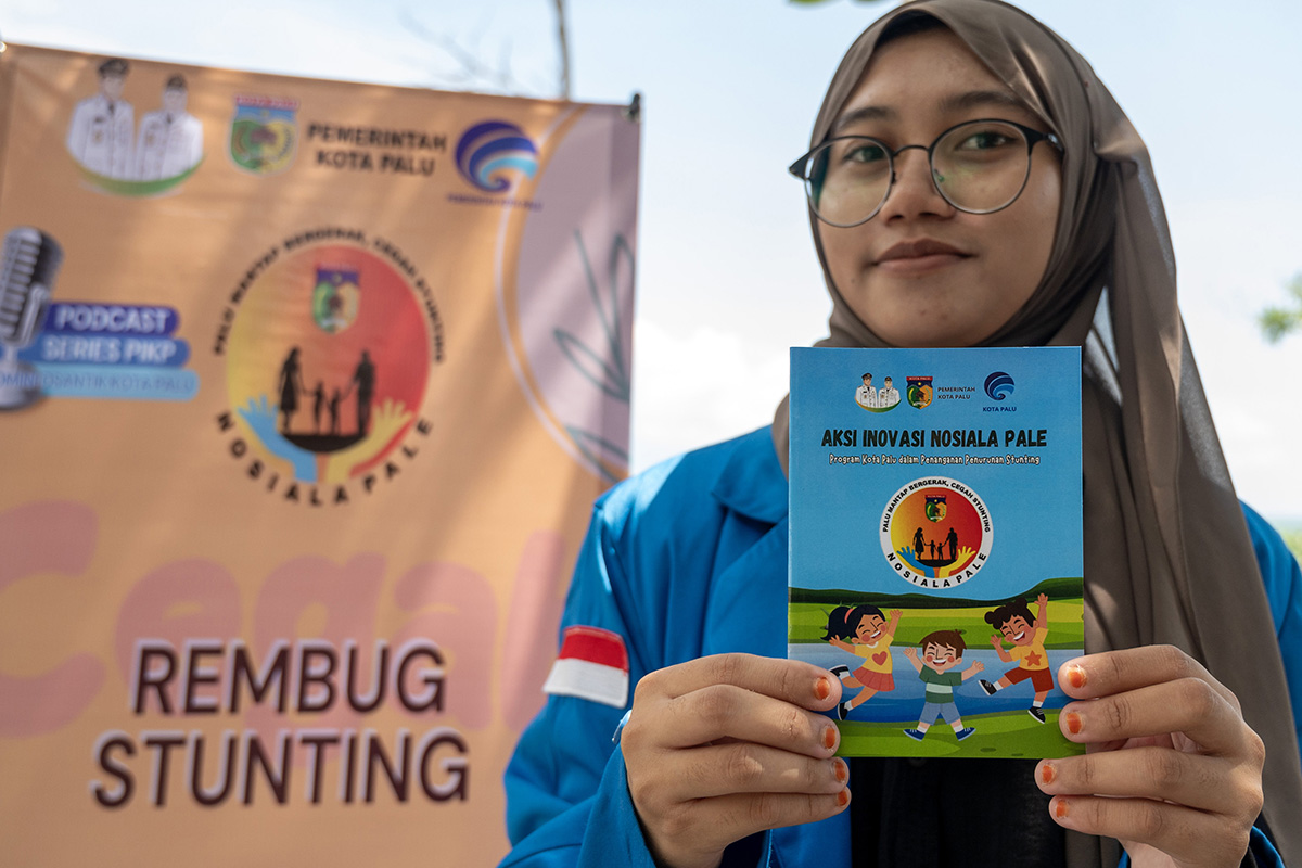 Seorang mahasiswa menunjukkan buku aksi penanganan stunting yang digunakan dalam implementasi program di lapangan pada Rembuk Stunting.