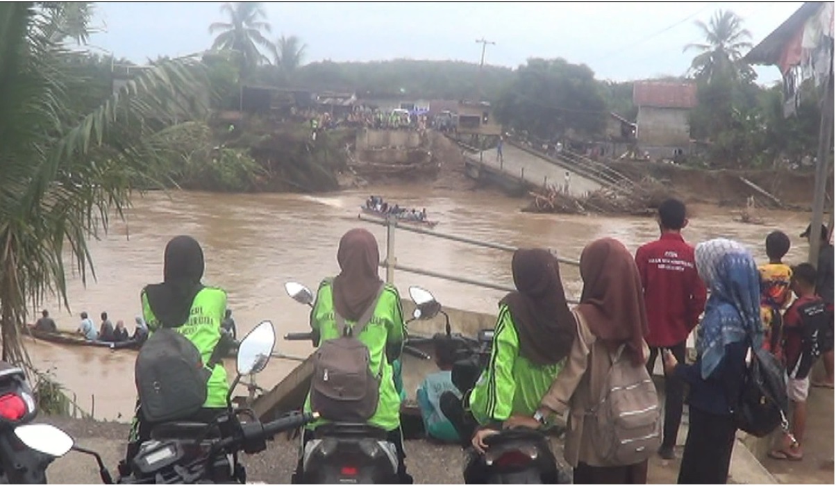 Para pelajar dan guru naik perahu melintasi sungai menuju ke sekolah.