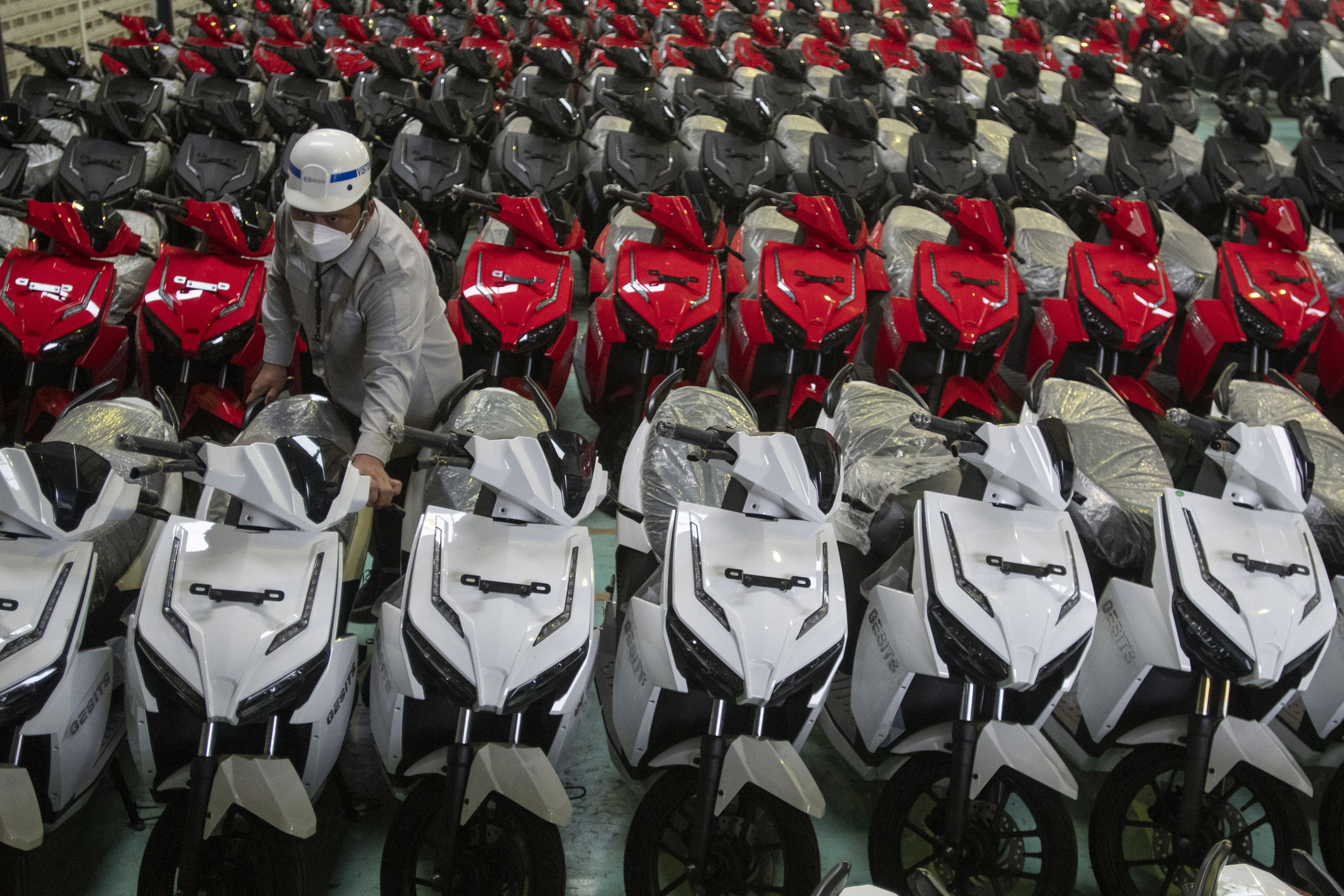 Pekerja menata sepeda motor listrik Gesits yang telah selesai dirakit.