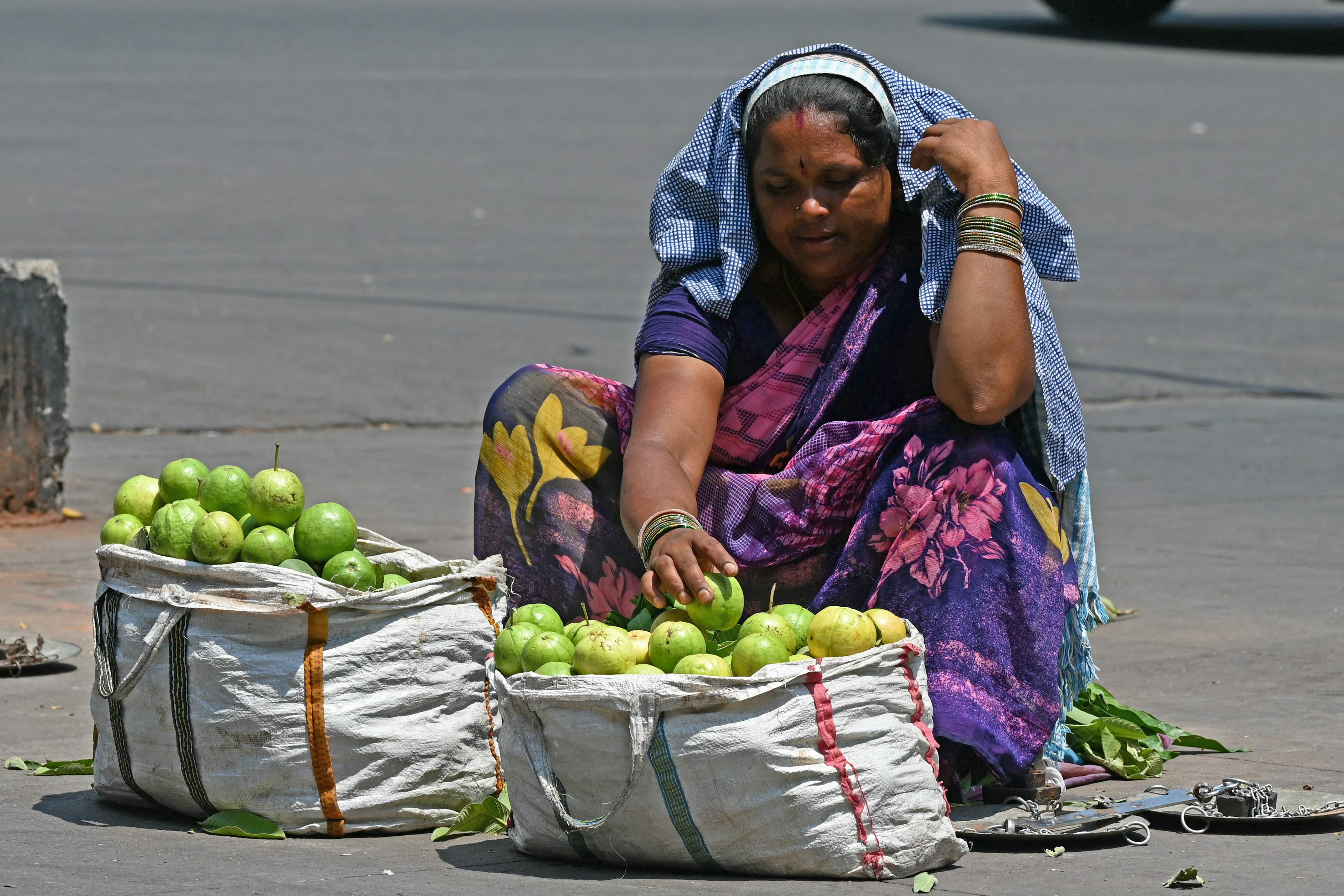 Pedagang buah di India berjualan di tengah teriknya matahari