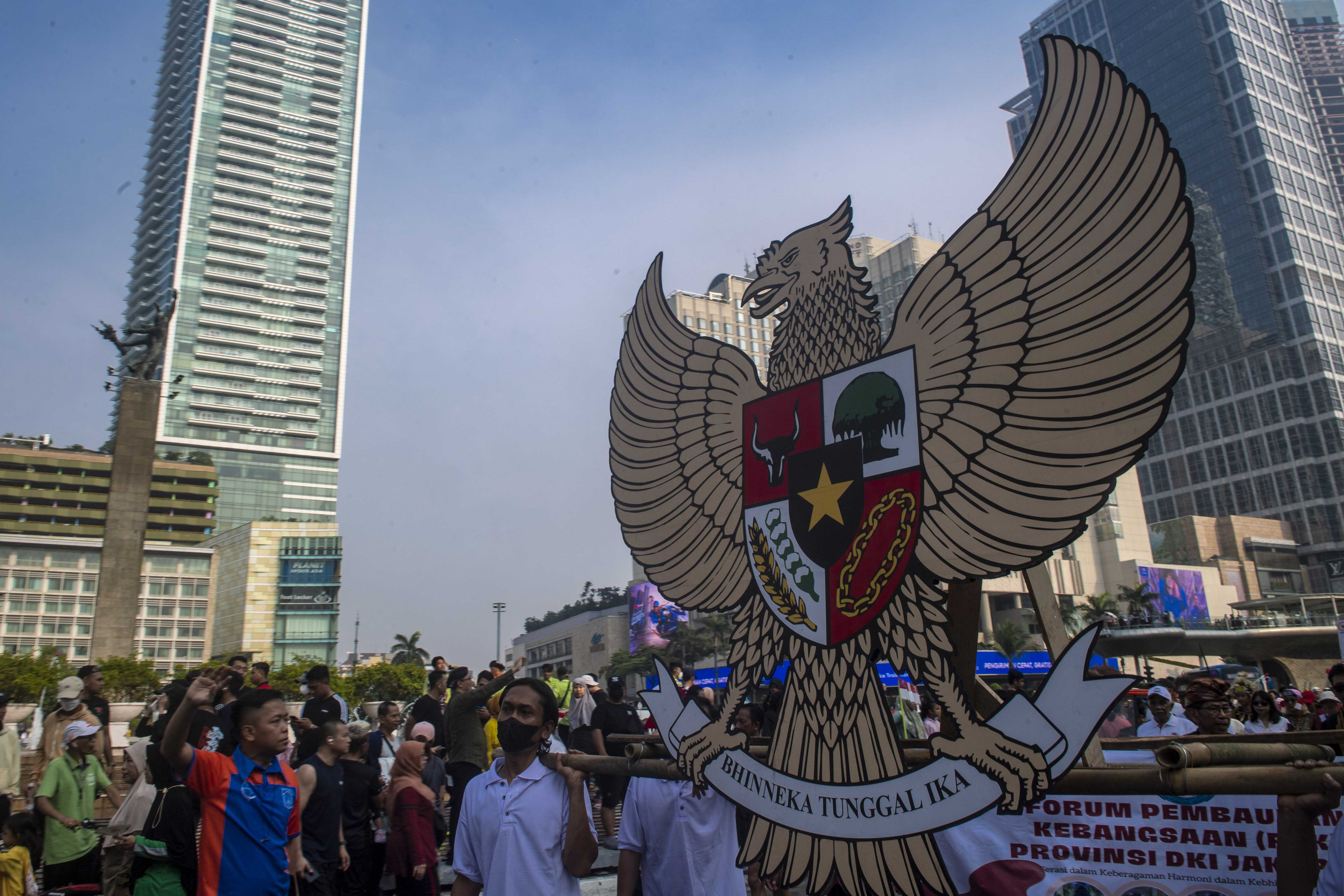 Warga membawa lambang Garuda Pancasila. 