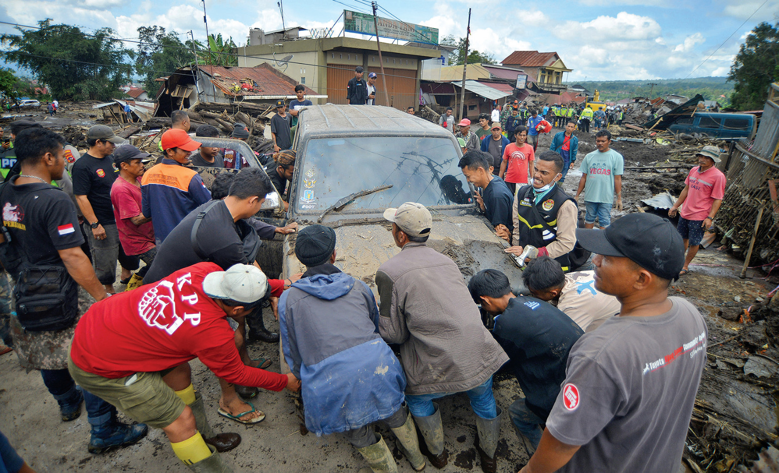 Tim SAR gabungan bersama warga mengevakuasi mobil yang terseret banjir bandang di Nagari Bukik Batabuah, Agam, Sumatra Barat, kemarin.