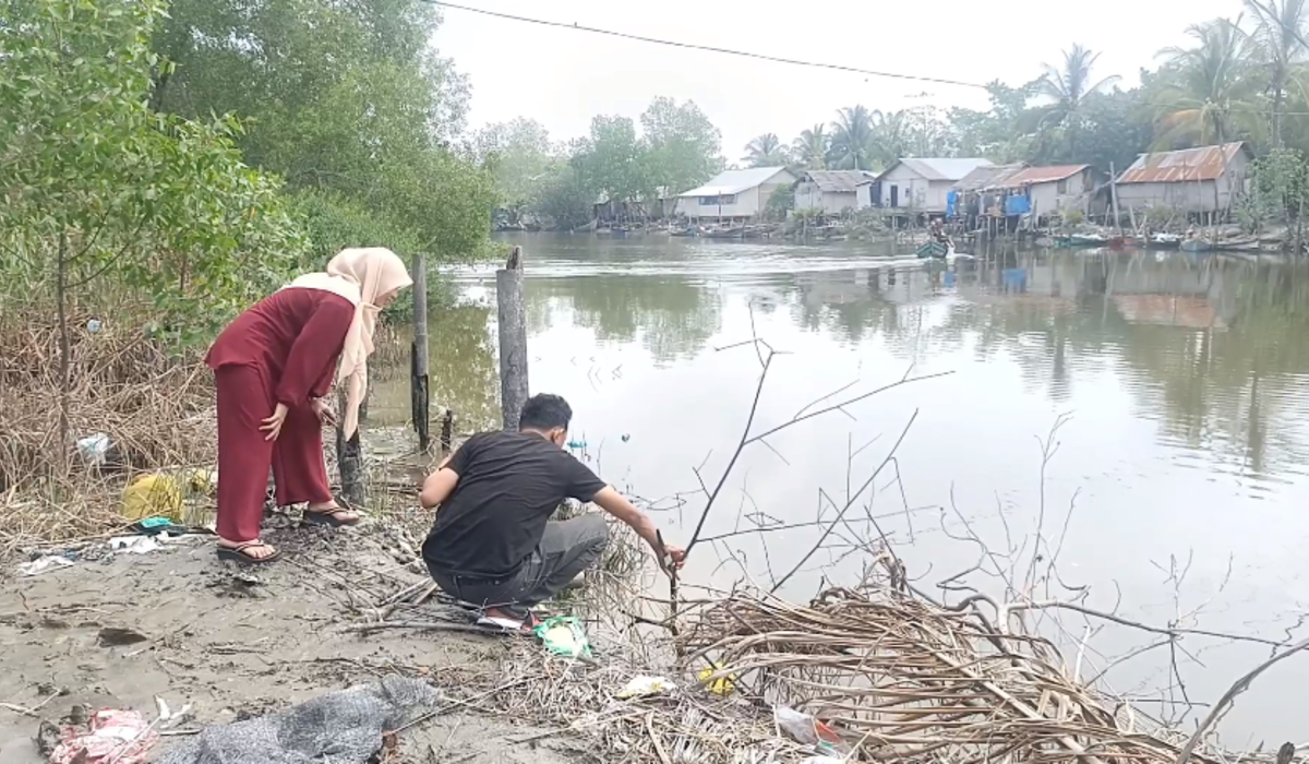 Warga menjaring ikan yang terdampar dan mengambang di sungai Batubara, Sumut.