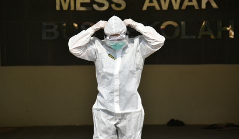 Petugas mengenakan APD bersiap diri sebelum menjemput pasien Covid-19. 