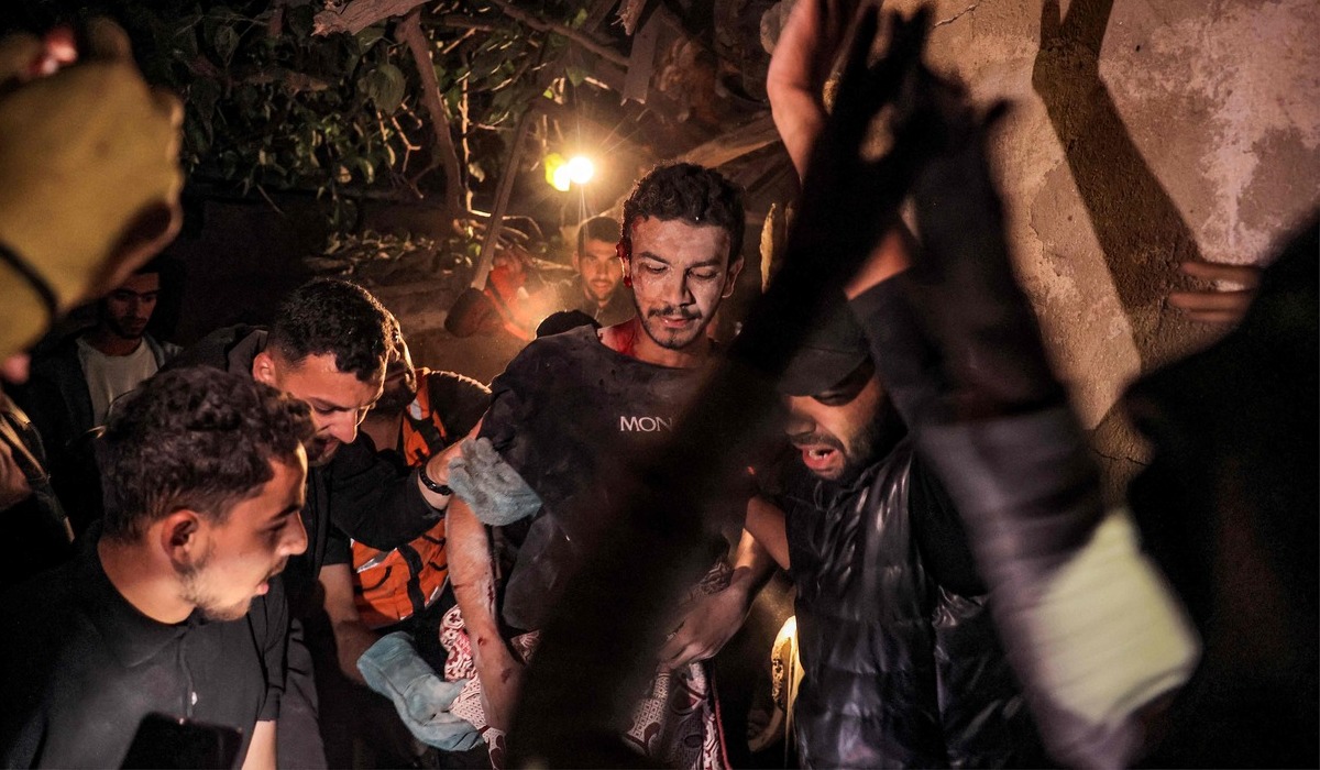 Warga saling membantu evakuasi korban serangan Israel di Rafah.