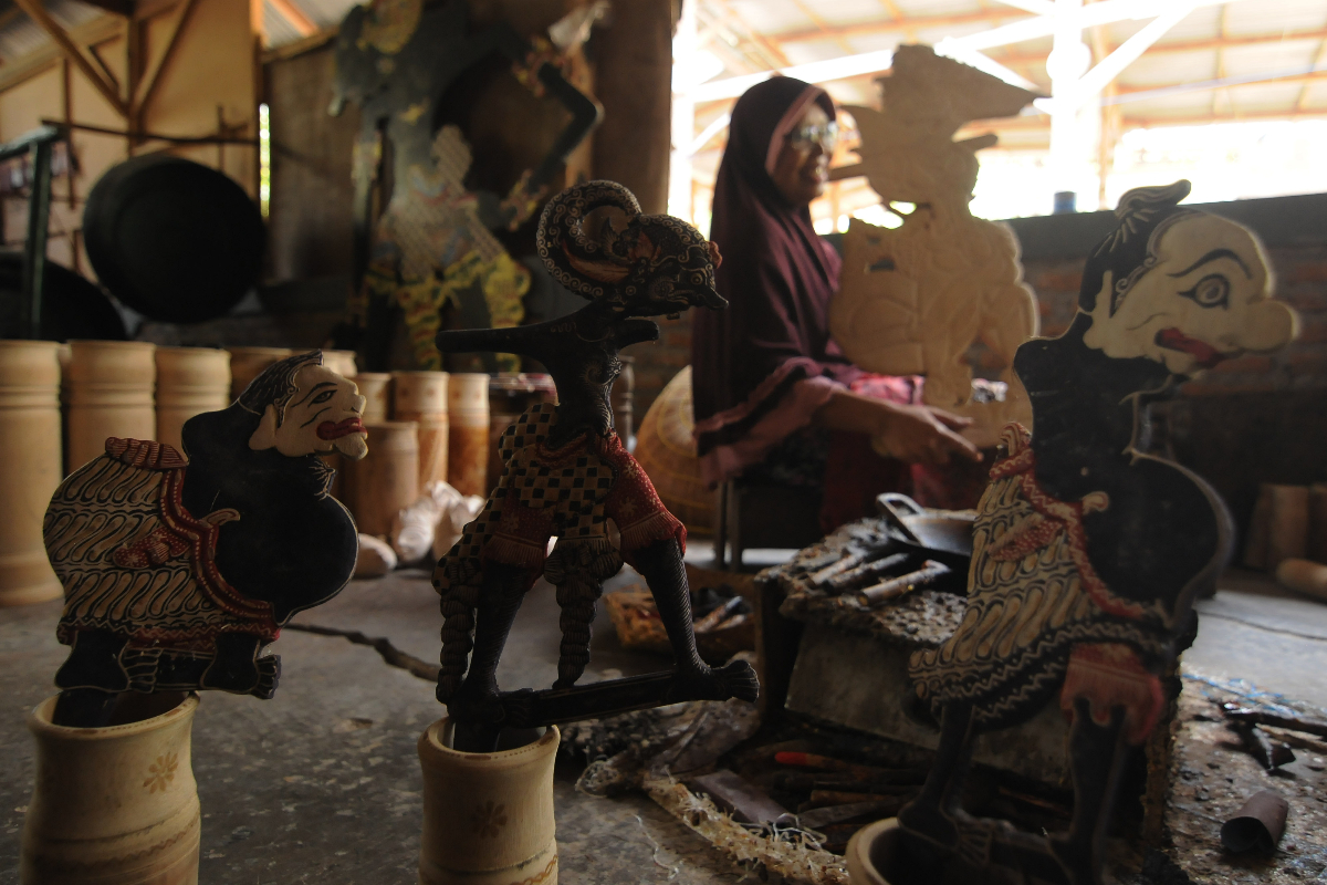 Perajin membatik kayu saat membuat kerajinan batik wayang kayu di Jarum, Bayat, Klaten, Jawa Tengah, Selasa (27/9/2022). Kementerian Koperas