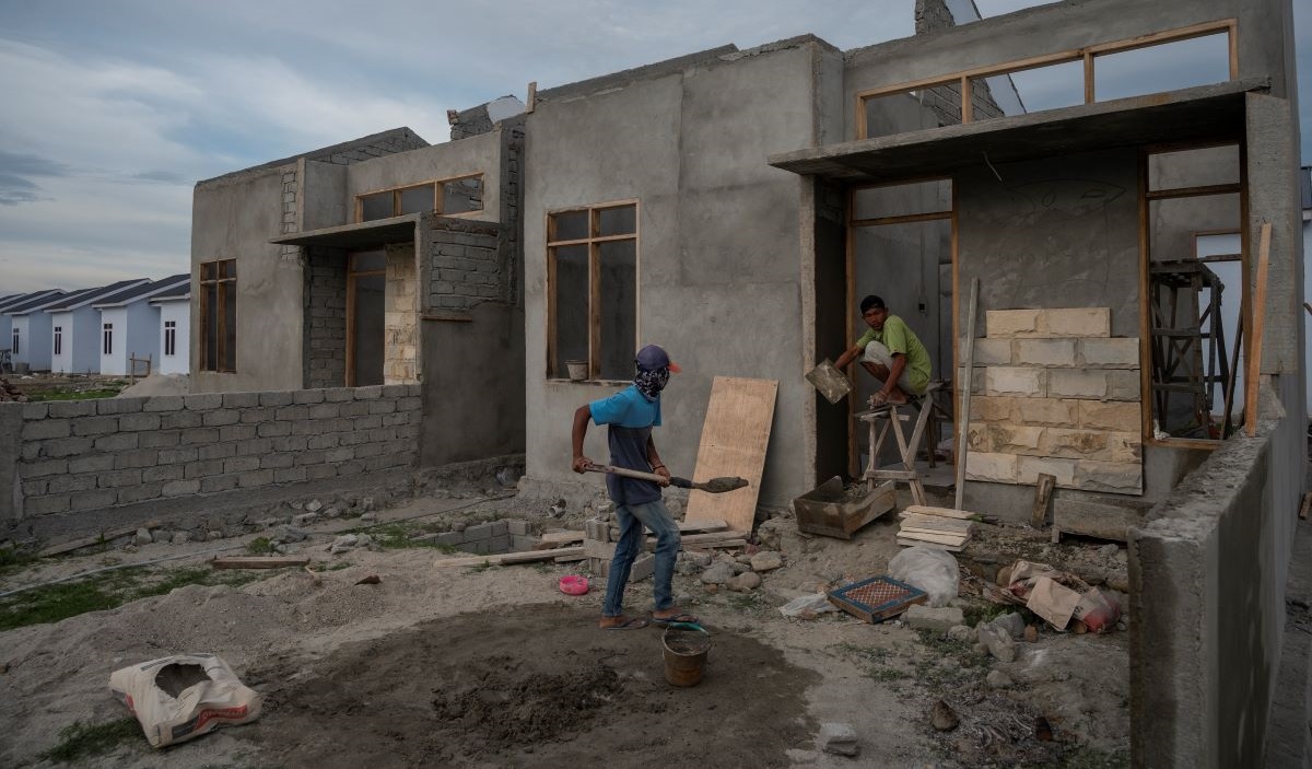 Pekerja menyelesaikan pembangunan perumahan di Desa Tinggede, Sigi, Sulawesi Tengah, Kamis (24/2/2022).