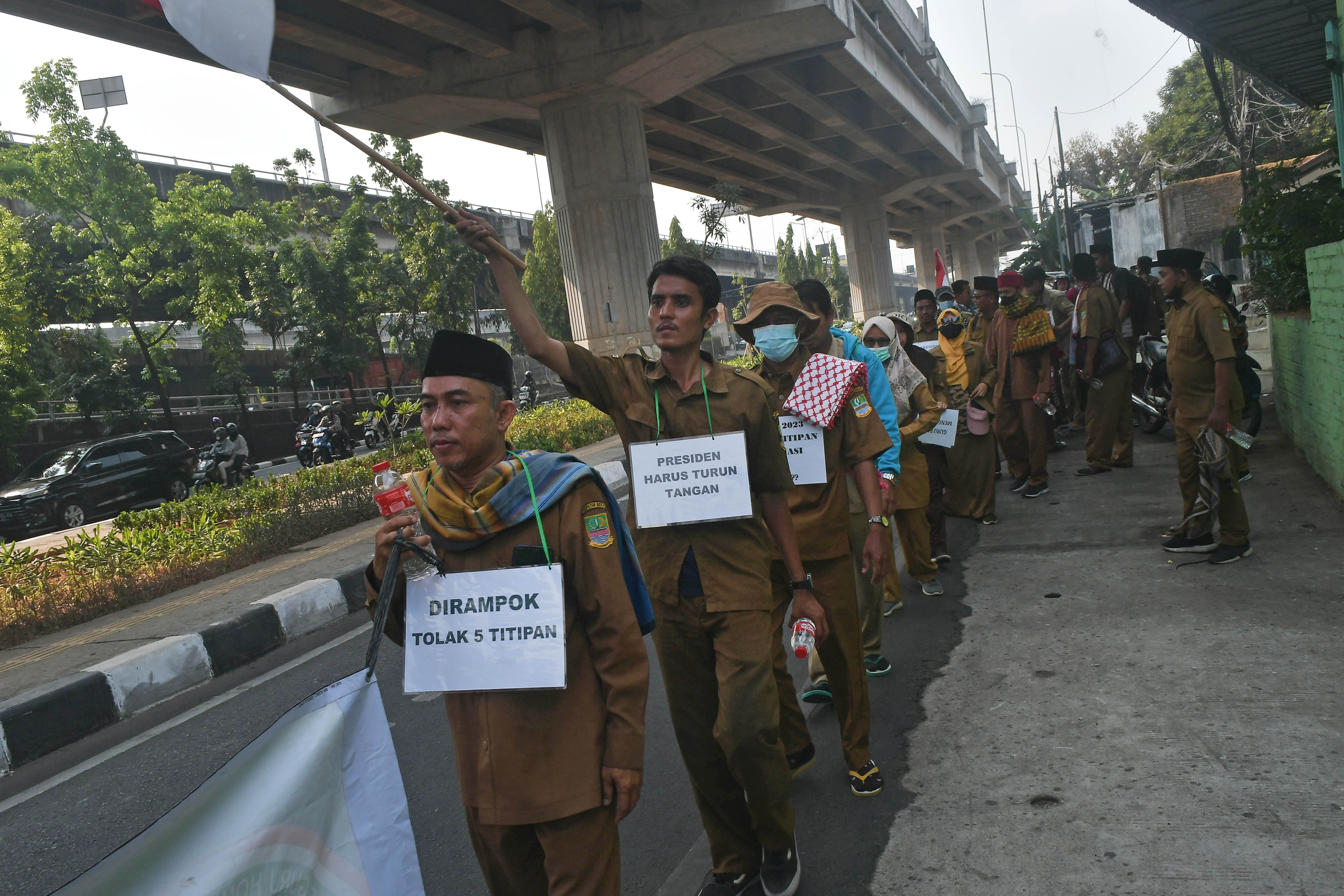 Guru honorer dari Kabupaten Bekasi melakukan aksi jalan kaki menuju Istana Negara saat melintas di Cawang, Jakarta Timur, Kamis (12/10/2023)