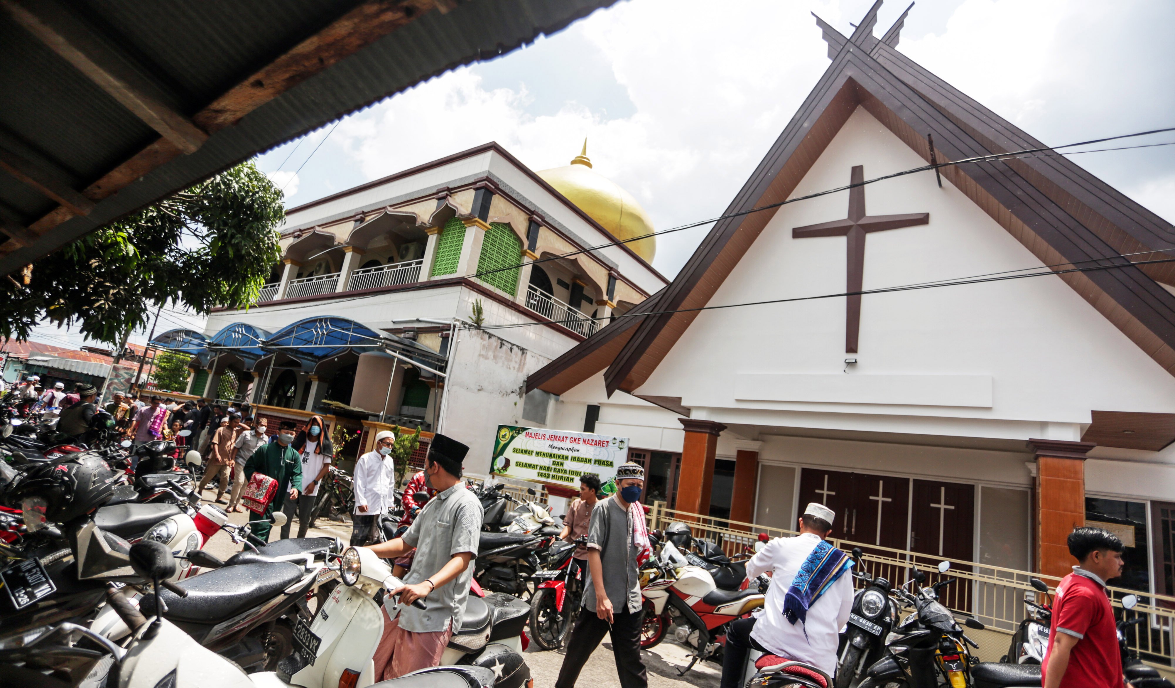 Ilustrasi: warga berjalan di kawasan Gereja Nazaret (kanan) dan Masjid Al Azhar (kiri) di Jalan Gemini, Palangka Raya, Kalimantan Tengah