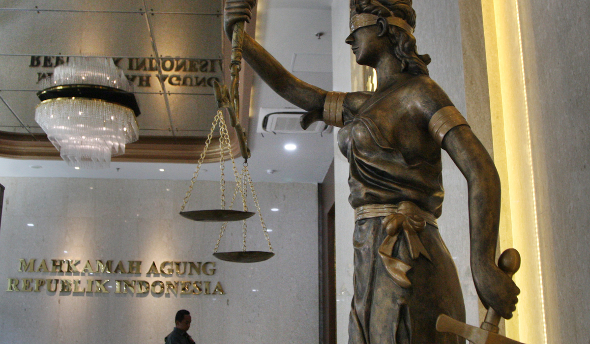 Staf Mahkamah Agung melewati pintu masuk Gedung Mahkamah Agung di Jakarta 