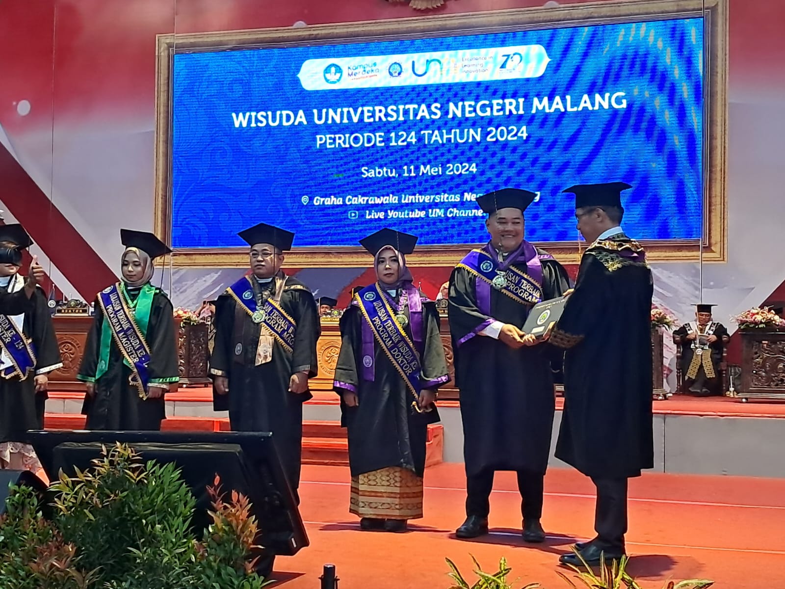 Novika Adi Wibowo menerima piagam dari Rektor Universitas Negeri Malang Prof. Dr. Hariyono, M.Pd di Gedung Graha Cakrawala Kampus UM.