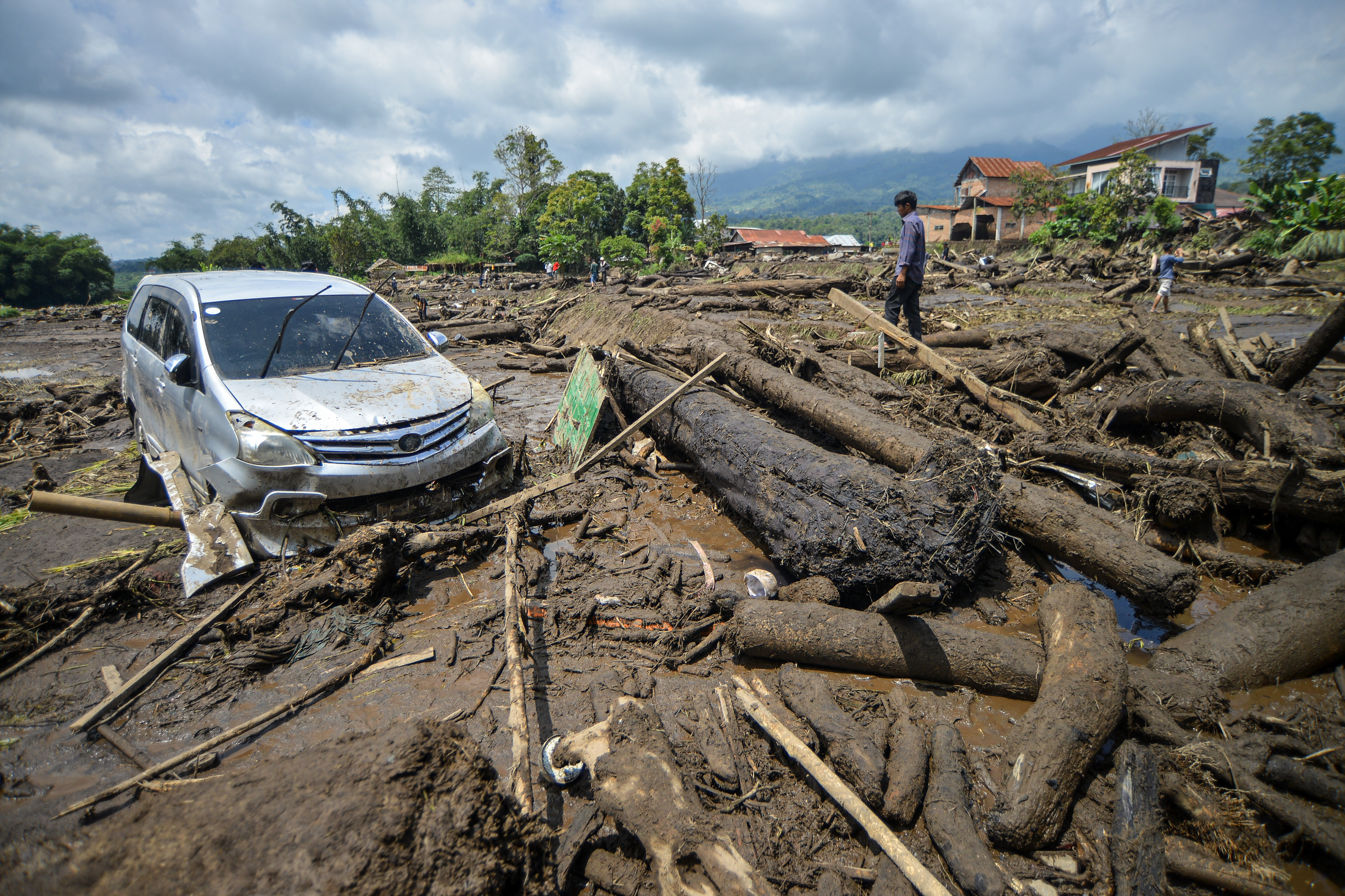Warga melihat sebuah mobil yang terdampak banjir bandang di Nagari Bukik Batabuah, Agam, Sumatera Barat.