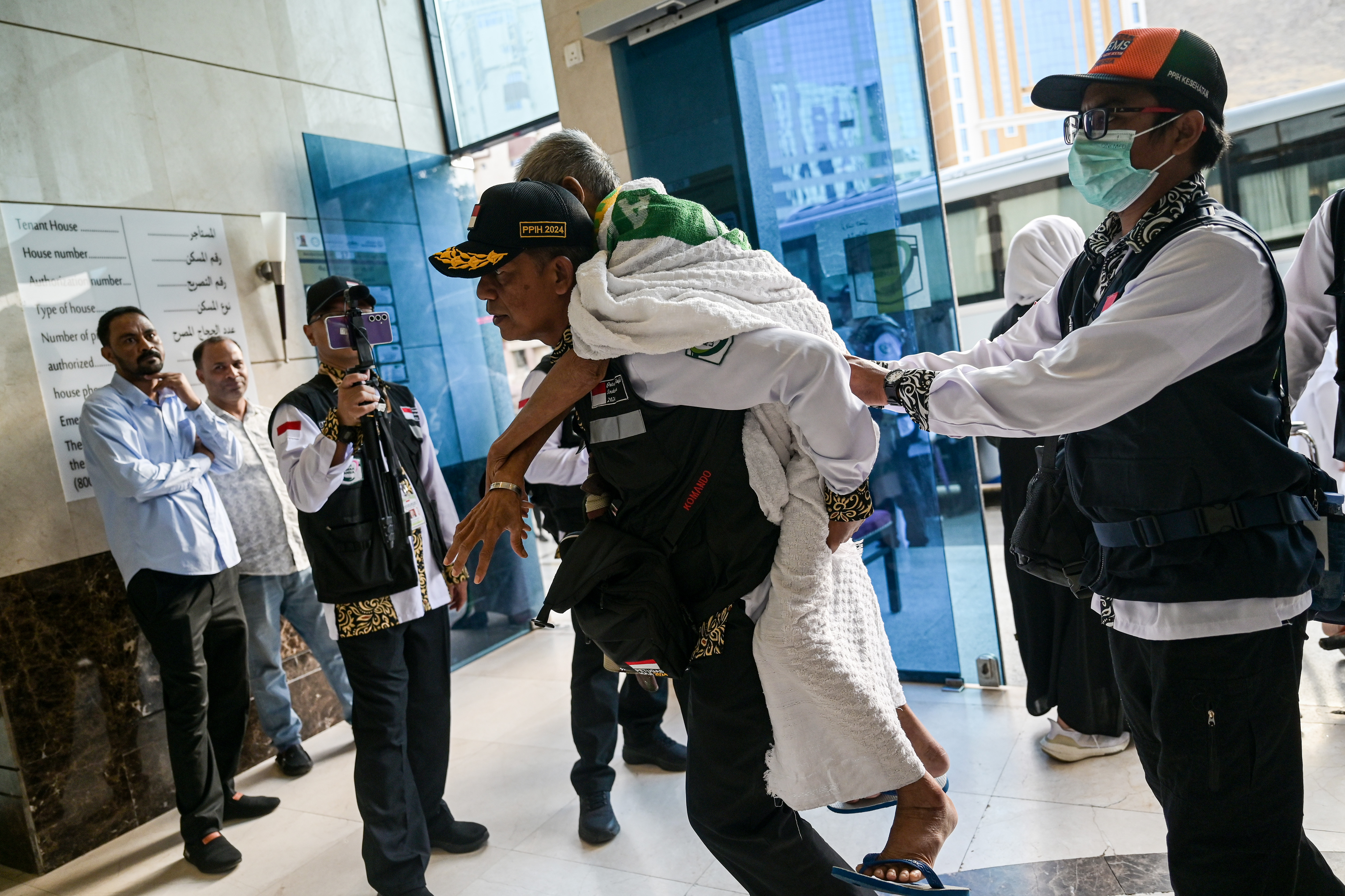 PPIH Daker Makkah menggendong calon haji Indonesia gelombang kedua kloter JKG-27 setibanya di hotel di Makkah, Arab Saudi, Jumat (24/5/2024)