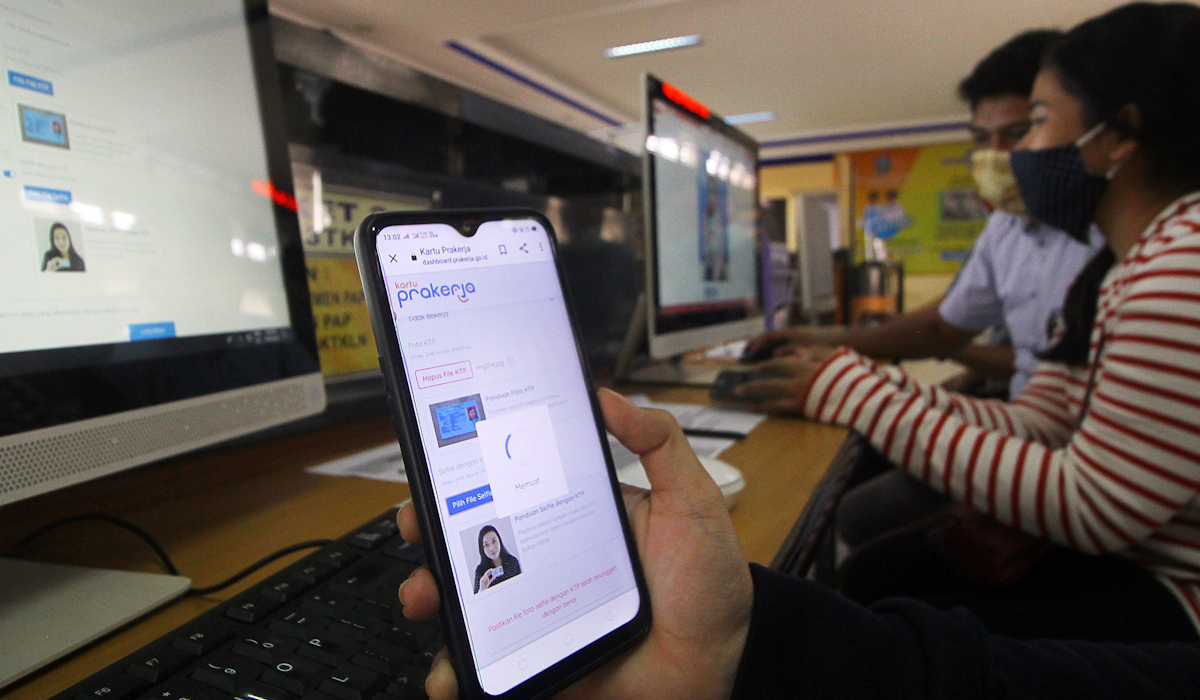 Petugas mendampingi warga yang melakukan pendaftaran calon peserta Kartu Prakerja 