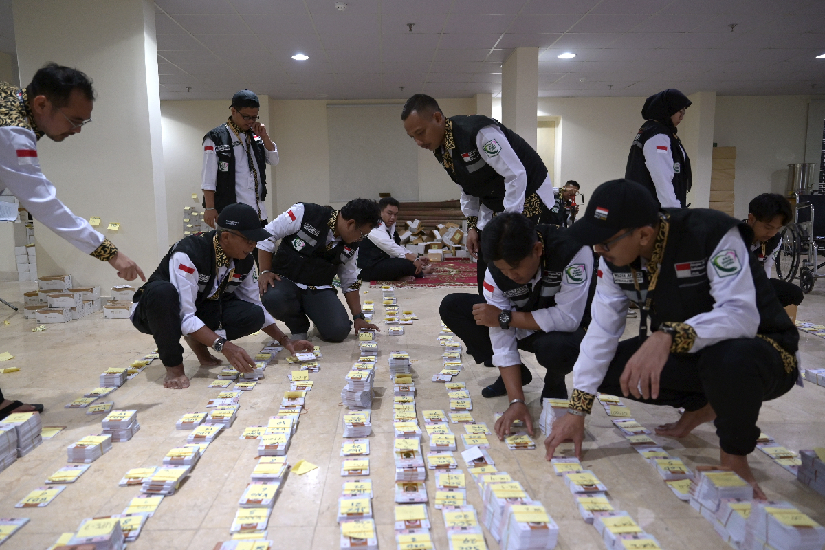 Petugas Penyelenggara Ibadah Haji (PPIH) bagian Media Center Haji membantu mengelompokkan kartu pintar atau smart card jamaah calon haji Ind