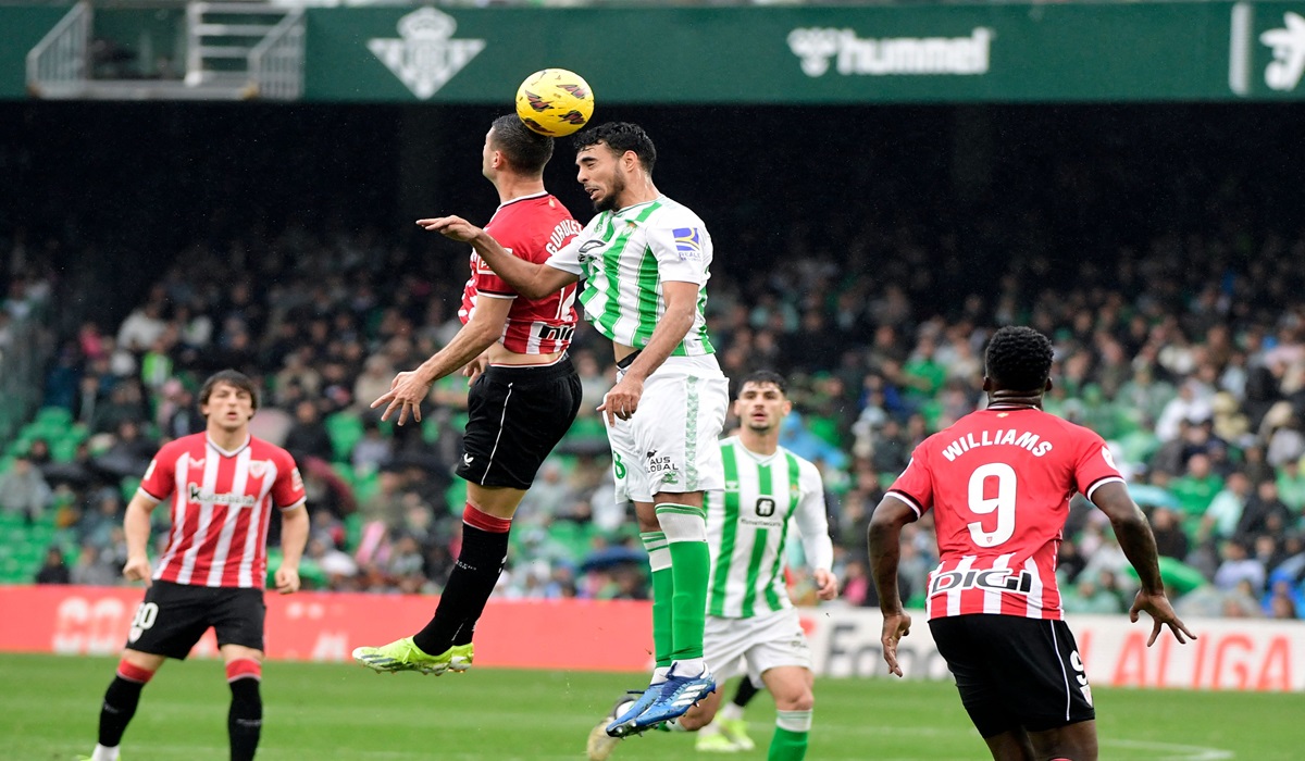 Bek Real Betis Chadi Riad (kanan) berduel udara dengan pemain Atletico Madrid