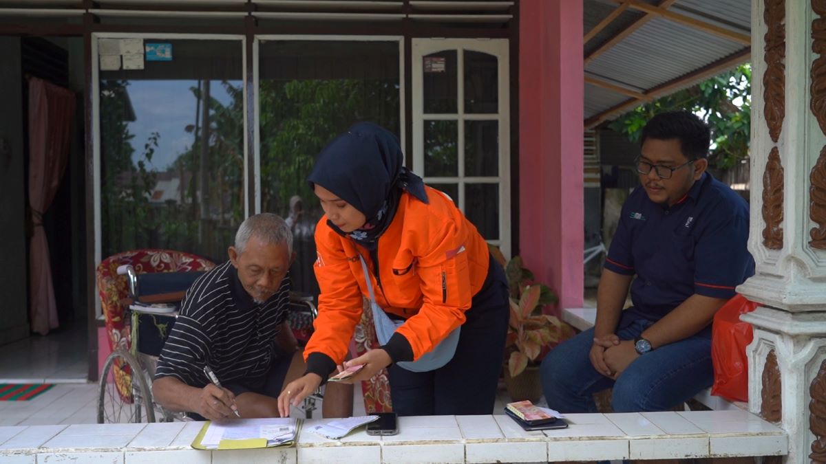 Petugas memberikan dana pensiun kepada penisunan.