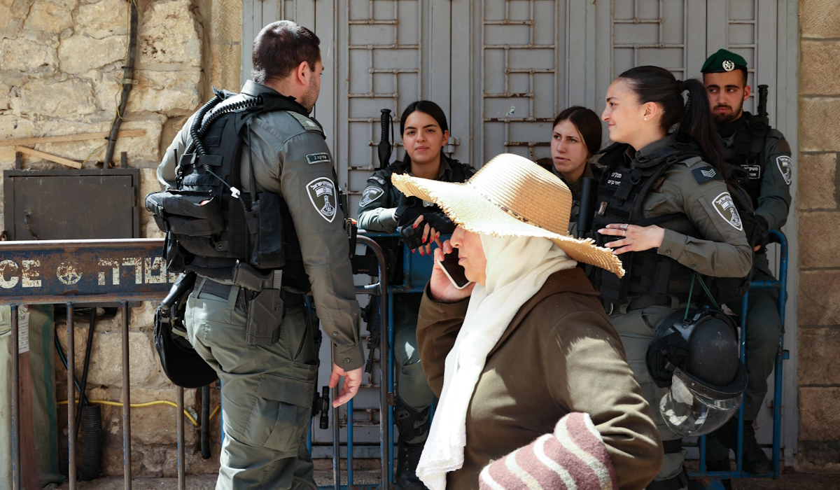 Anggota pasukan keamanan Israel berjaga ketika seorang wanita Palestina menuju ke Masjid Al-Aqsa melalui Gerbang Damaskus di Yerusalem