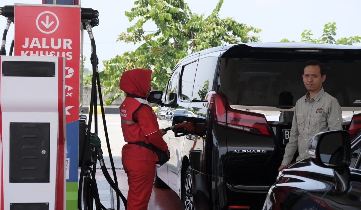 Petugas SPBU sedang mengisi BBM kendaraan pribadi.