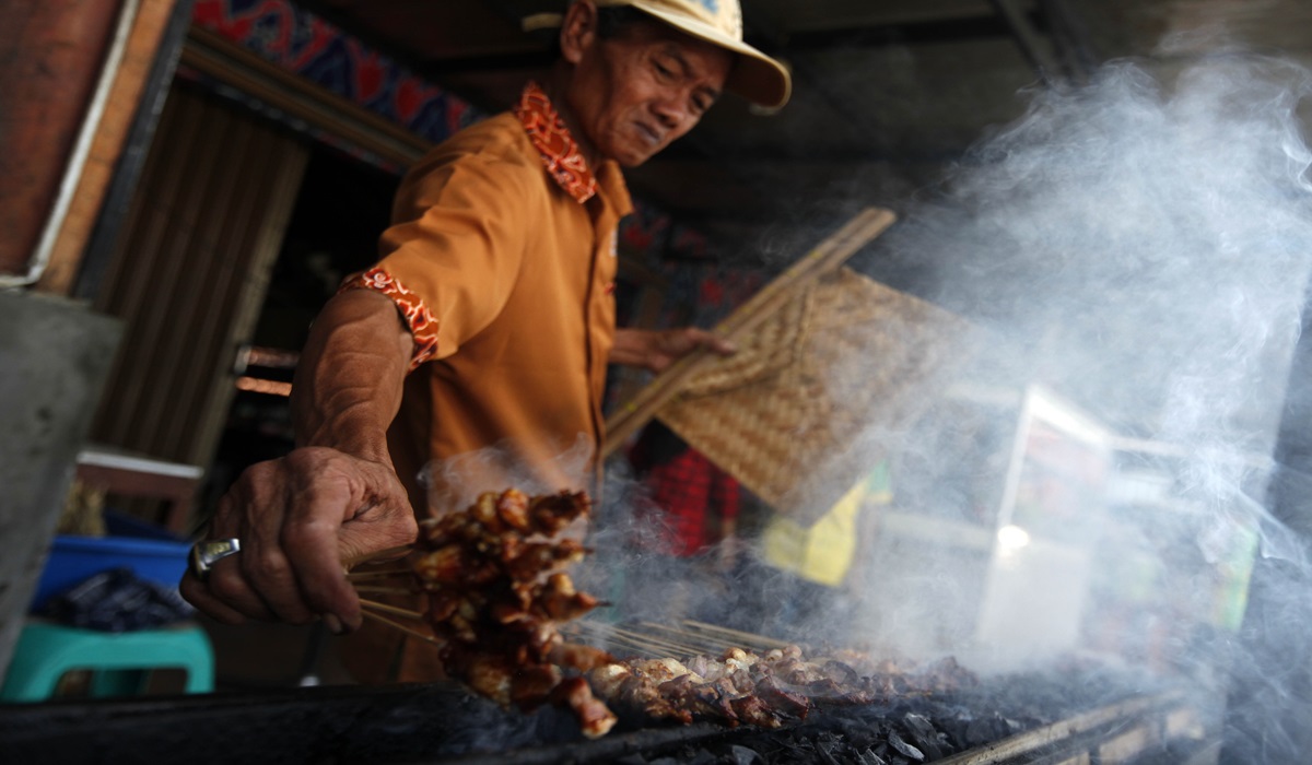 Ilustrasi--Seorang pedagang membakar sate kambing