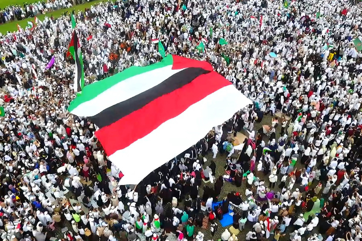 Peserta Aksi Bela Palestina membentangkan bendera Merah Putih dan bendera Palestina.