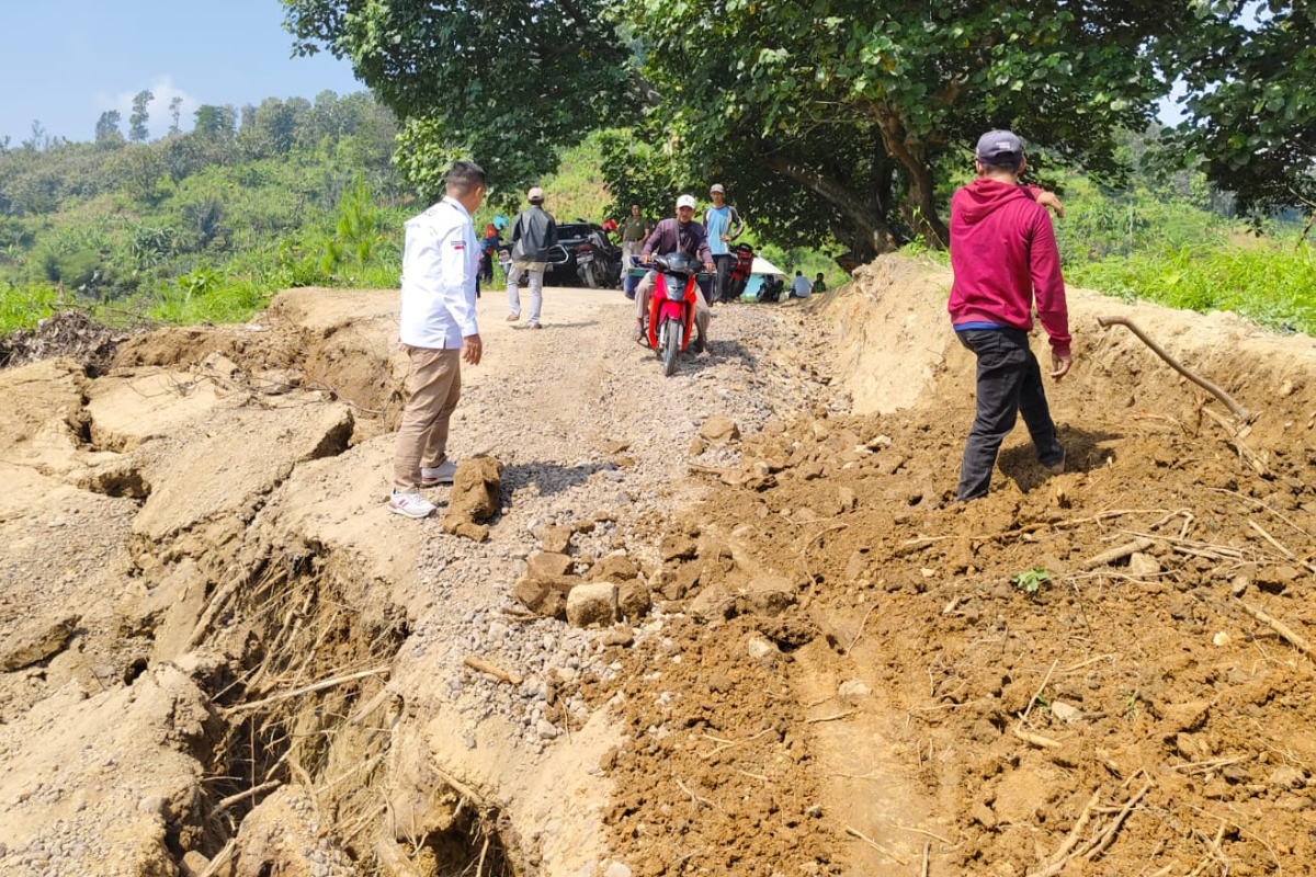 Kepala Desa Cibadak Elan Hermawan (kiri/kemeja warna putih) mengecek kondisi ruas jalan utama di Kampung Pangangonan Desa Cibadak Kecamatan 