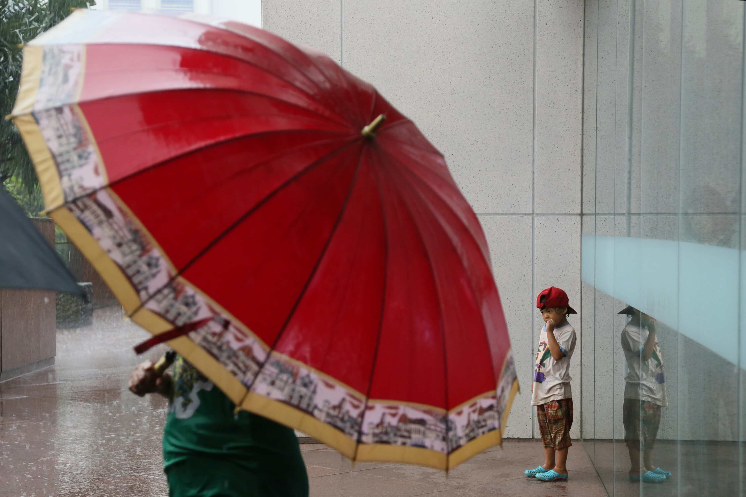 Penjual jasa ojek payung menjajakan jasa ojek kepada karyawan kantor di Jakarta, Rabu (1/4/2014).