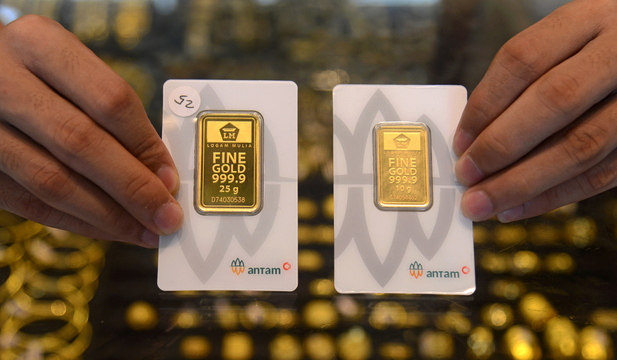 Pedagang memperlihatkan emas produksi PT Aneka Tambang Tbk (Antam).